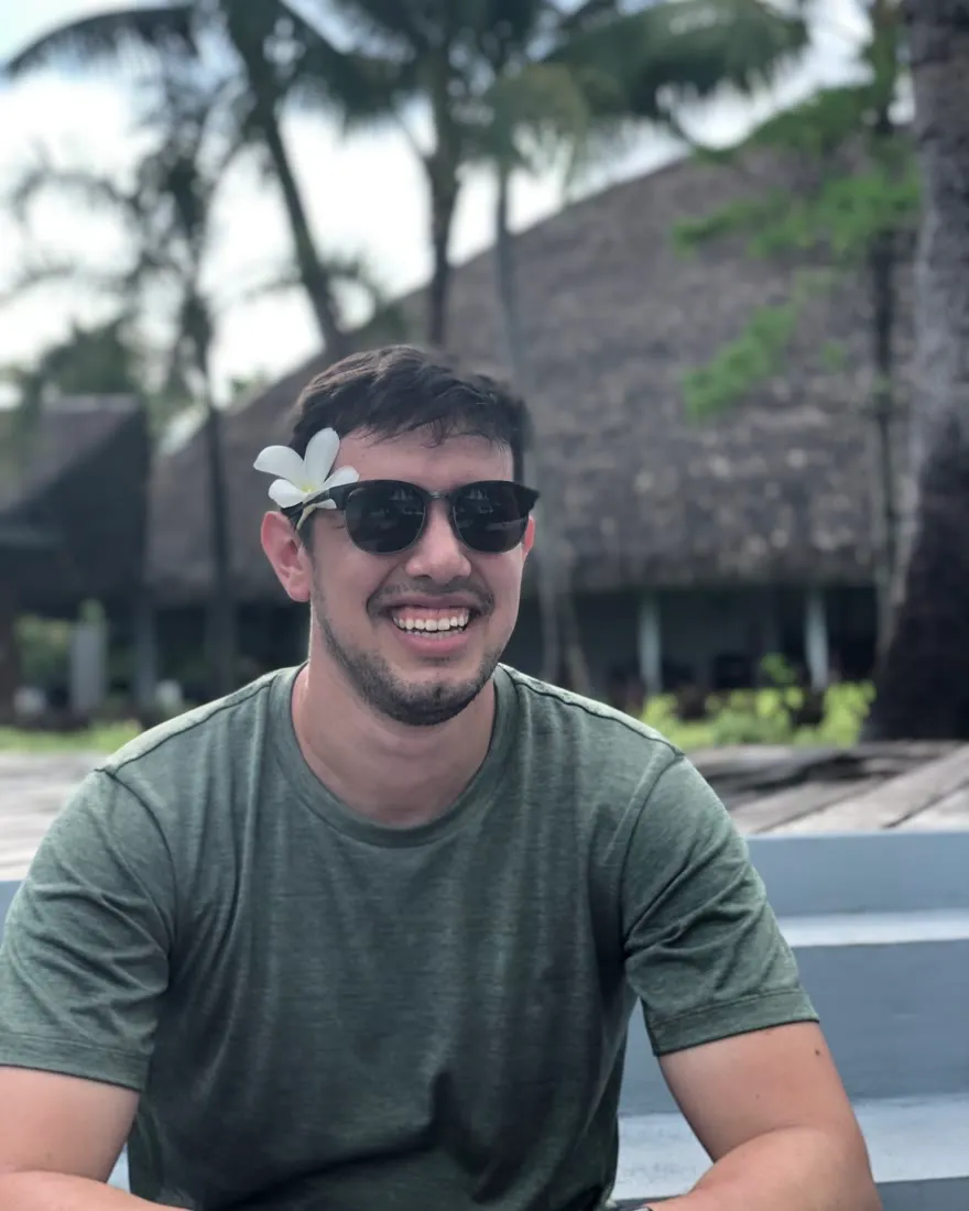 Josef, laughing, with a plumeria tucked behind one ear